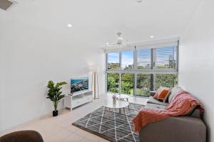 a living room with a couch and a large window at Cozy 1 bedroom in the Heart of South Brisbane with parking in Brisbane