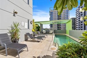 eine Terrasse mit Stühlen und einem Pool in der Unterkunft Cozy 1 bedroom in the Heart of South Brisbane with parking in Brisbane
