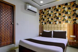 sypialnia z dużym łóżkiem z drewnianym zagłówkiem w obiekcie OYO Hotel Angel Park w mieście Ahmadabad