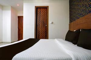 sypialnia z łóżkiem i drewnianymi drzwiami w obiekcie OYO Hotel Angel Park w mieście Ahmadabad
