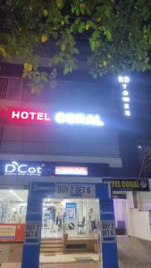 uma loja em frente a um hotel com um sinal azul em Hotel Coral em Indore