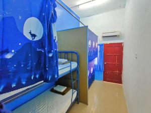 a small room with a bunk bed and a red door at Tekoma Resort Taman Negara in Kuala Tahan
