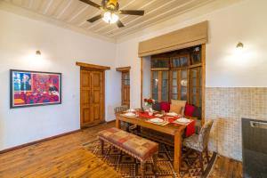 a dining room with a table and a ceiling fan at StayVista at Paris Villa with Pvt Pool & Valley View in Kasauli +22 photos
