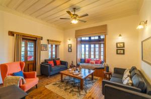 a living room with furniture and a ceiling fan at StayVista at Paris Villa with Pvt Pool & Valley View in Kasauli