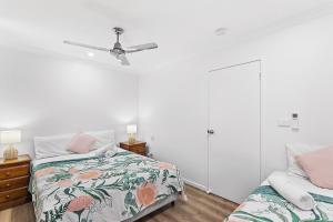 1 dormitorio con 1 cama y ventilador de techo en Unit 1 Sunbird on Lamond en Airlie Beach