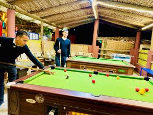 a man playing a game of pool with a cue at maison d'hôtes yamine in Beni Mellal