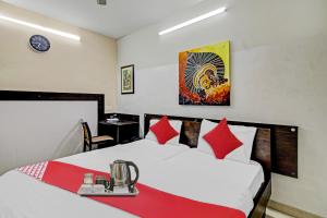 Habitación de hotel con cama con manta roja en Super OYO Flagship Hotel Diva Inn en Nagpur