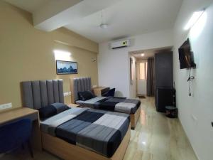 a hotel room with two beds and a tv at Collection O Local Square Karle Town in Bengaluru