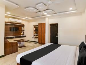 1 dormitorio con 1 cama grande y TV en OYO Rj Royal Inn en Vellore