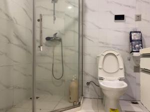 a bathroom with a toilet and a glass shower at Hangzhou inn Time Youth Hostel in Hangzhou