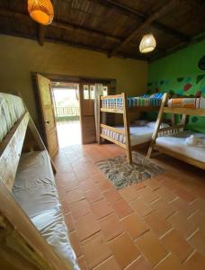 a room with three bunk beds and a doorway at Hostal El Santuario in Minca