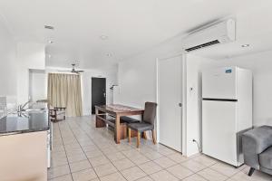 een keuken en eetkamer met een tafel en een koelkast bij Unit 1 Sunbird on Lamond in Airlie Beach