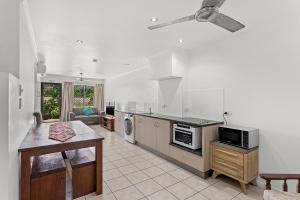 a kitchen with a table and a stove top oven at Unit 1 Sunbird on Lamond in Airlie Beach
