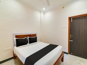 1 dormitorio con 1 cama grande y puerta en OYO Rj Royal Inn en Vellore