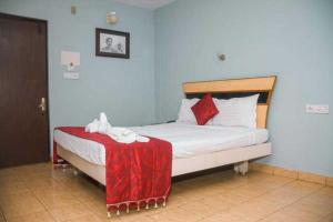 a bedroom with a bed with a red blanket on it at OYO Hotel Nico in Port Blair