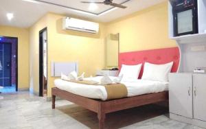 um quarto com uma cama grande e uma cabeceira vermelha em OYO Hotel Nico em Port Blair