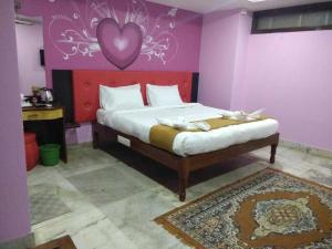 um quarto com uma cama com um coração na parede em OYO Hotel Nico em Port Blair