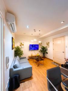 a living room with a couch and a table at The Gramercy Residences by ASG in Manila