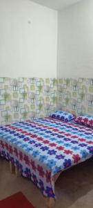 1 cama con manta roja blanca y azul en Maharishi Valmiki Homestay, en Ayodhya