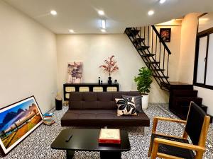 a living room with a couch and a staircase at Old Quarter Centre Duplex 2BR w Netflix_Wifi in Hanoi