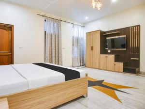 盧迪亞納的住宿－OYO Hotel Blue 7，一间卧室配有一张床和一台平面电视