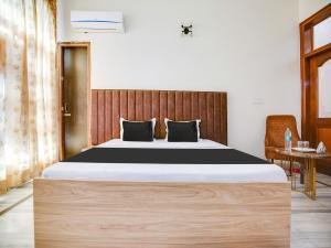 盧迪亞納的住宿－OYO Hotel Blue 7，一间卧室配有一张大床和木制床头板