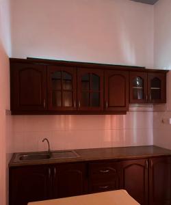 a kitchen with wooden cabinets and a sink at Village Inn Resort in Negombo