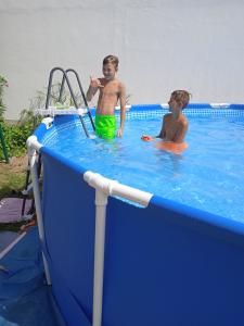 two people are in a swimming pool at lovely House to 16 - near the town of Rab whit Children's pool, playground, garden, parking lot, grill, terraces, in Rab