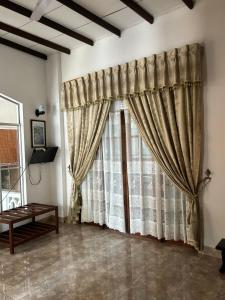 a room with a large window with curtains at Village Inn Resort in Negombo