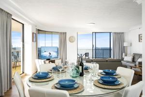 uma sala de jantar com mesa e cadeiras e uma sala de estar em Aegean Apartments - Q Stay em Gold Coast