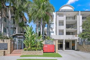 un edificio de apartamentos con una nevera roja delante de él en Centro at Toowong - Modern Spacious Living with Pool en Brisbane