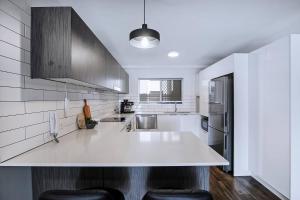 a white kitchen with a large white counter top at Centro at Toowong - Modern Spacious Living with Pool in Brisbane