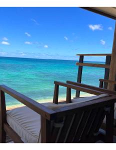 a bench on a beach with a view of the ocean at Hummingbird Oceanfront Cottage in Hauula