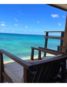 - un banc sur une plage avec vue sur l'océan dans l'établissement Hummingbird Oceanfront Cottage, à Hauula