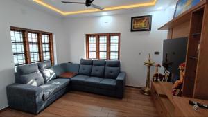 a living room with a blue couch and a tv at Tranquil Home in Trivandrum