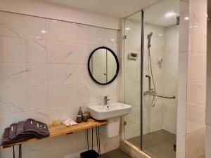 a bathroom with a sink and a shower with a mirror at Old Quarter Centre Duplex 2BR w Netflix_Wifi in Hanoi