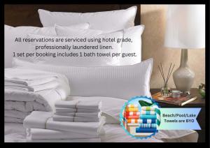 a white bed with a pile of towels and a lamp at King 2 - close proximity to Bimbadgen and Hope Estate concerts in Pokolbin