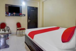 a bedroom with a bed and a tv and a door at Flagship Sk Brother Hotel in Patna