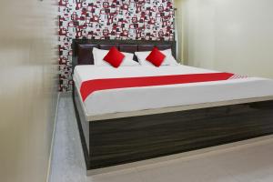 Flagship Sk Brother Hotel في باتنا: سرير مع وسائد حمراء في الغرفة