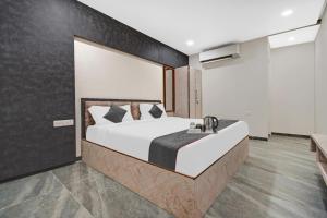 a bedroom with a large bed and a sink at Townhouse OAK Hotel Rudra in Jaipur