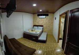トルトゥゲーロにあるTortuguero7 lake viewのベッド1台とソファが備わる小さな客室です。