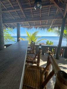 a large wooden table with a view of the ocean at ZenStay Retreats Private Luxury Beach House Rental in Pandan