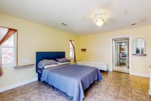 um quarto com uma cama azul e paredes amarelas em The Peaceful Ocala Bungalow em Ocala