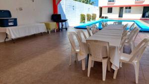 alberca Blass في كواتزاكوالكوس: طاولة وكراسي بجانب مسبح