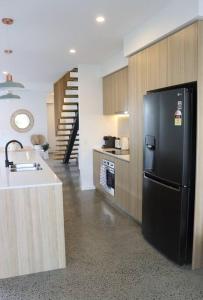 a kitchen with a black refrigerator and a sink at Beautiful Duplex in Miami - Close to the Beach in Gold Coast