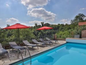 una piscina con sillas y sombrillas junto a una piscina en Barbera at Villa Pesce, en Mombaruzzo