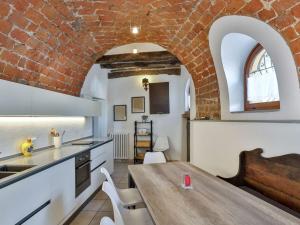 cocina con mesa y pared de ladrillo en Barbera at Villa Pesce, en Mombaruzzo