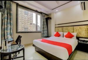 Hotel India continental في نيودلهي: غرفة الفندق بسرير وطاولة زجاجية