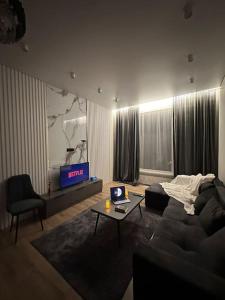 - un salon avec un canapé et une télévision dans l'établissement ЖК2 Estet147, à Almaty