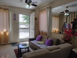 a living room with a couch and purple pillows at Eurie's Furnished Unit in Butuan